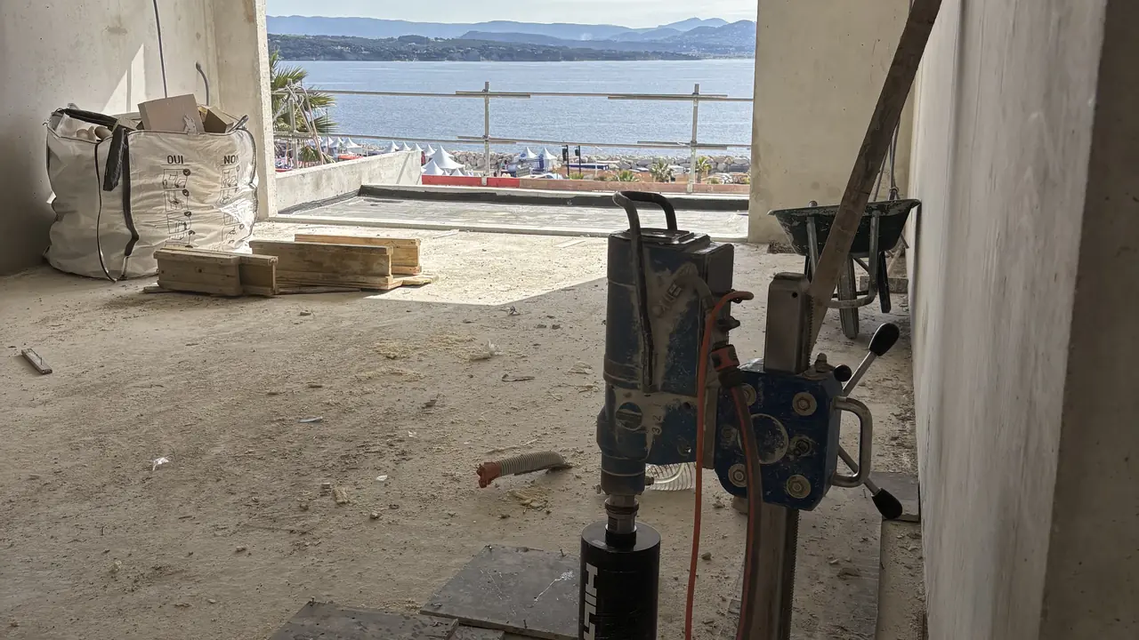Carotteuse sur colonne en cours de carottage d'une dalle béton sur un chantier à La Ciotat