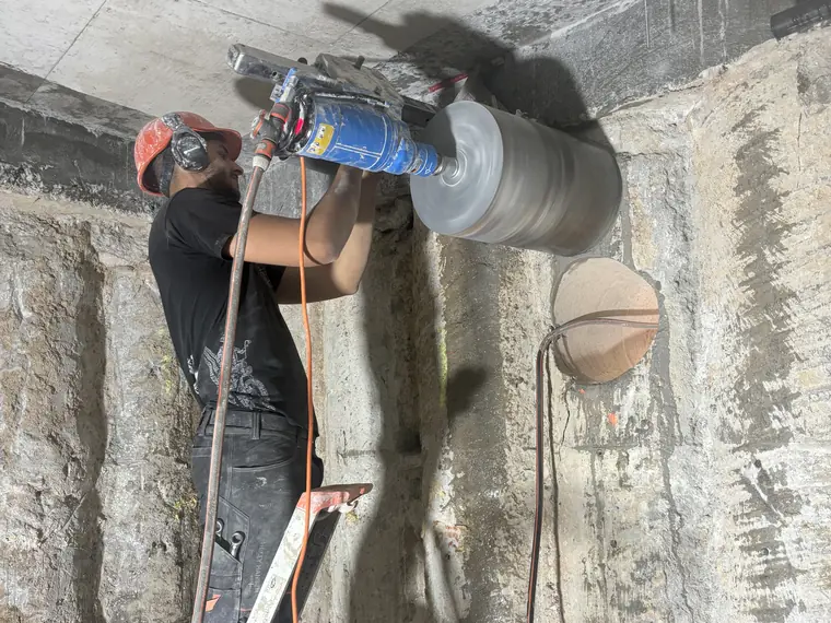 Opérateur MANZALCO réalisant un carottage de 300 mm de diamètre dans un mur béton de 80 cm d'épaisseur à Aix-en-Provence