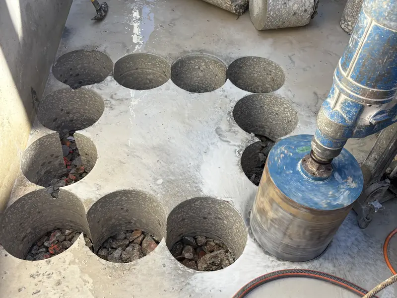 Carottages traversants réalisés dans une dalle béton, carottes extraites posées au sol